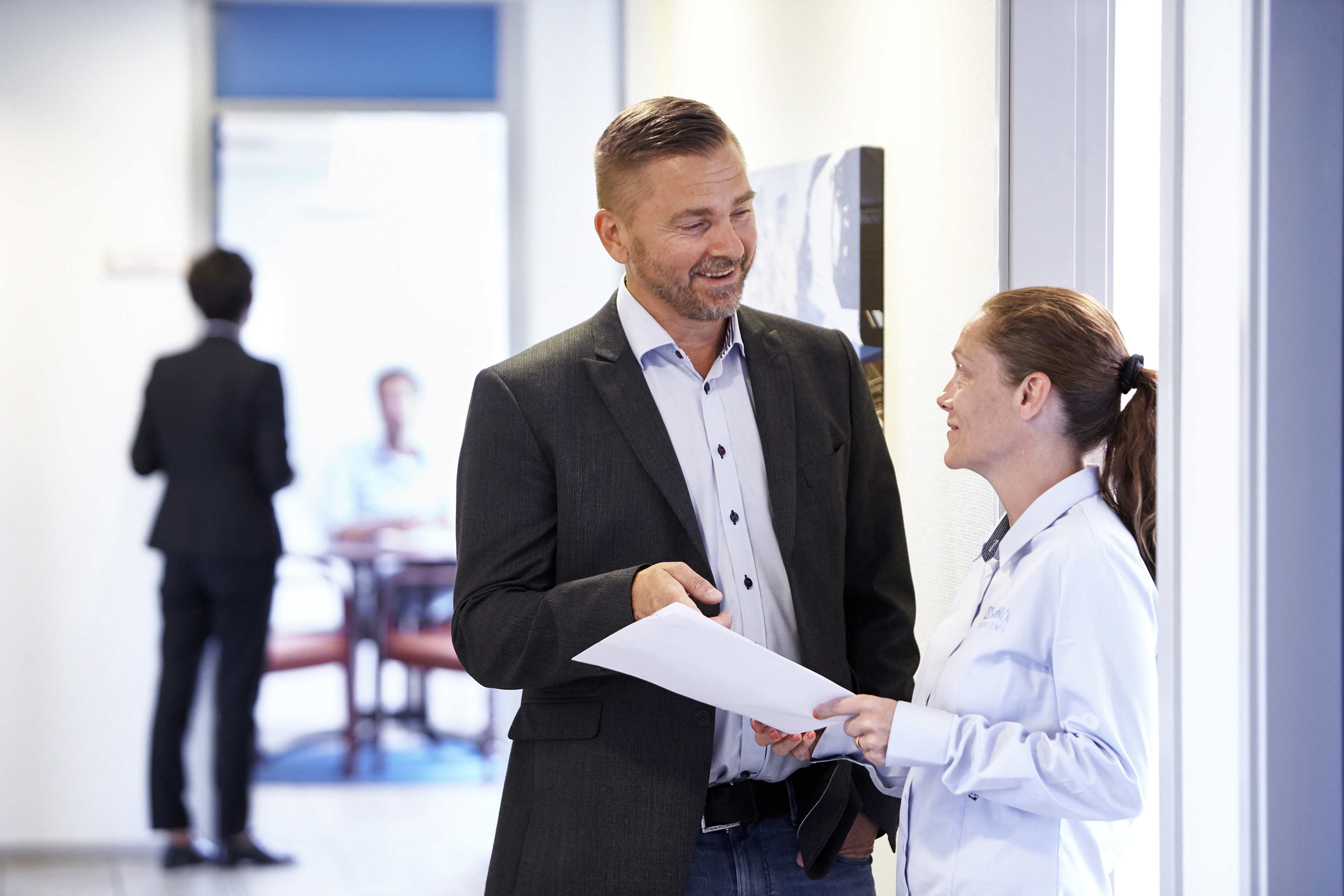 En medarbetare inom Stena Metallkoncernen och en affärspartner har en diskussion i en modern kontorsmiljö.