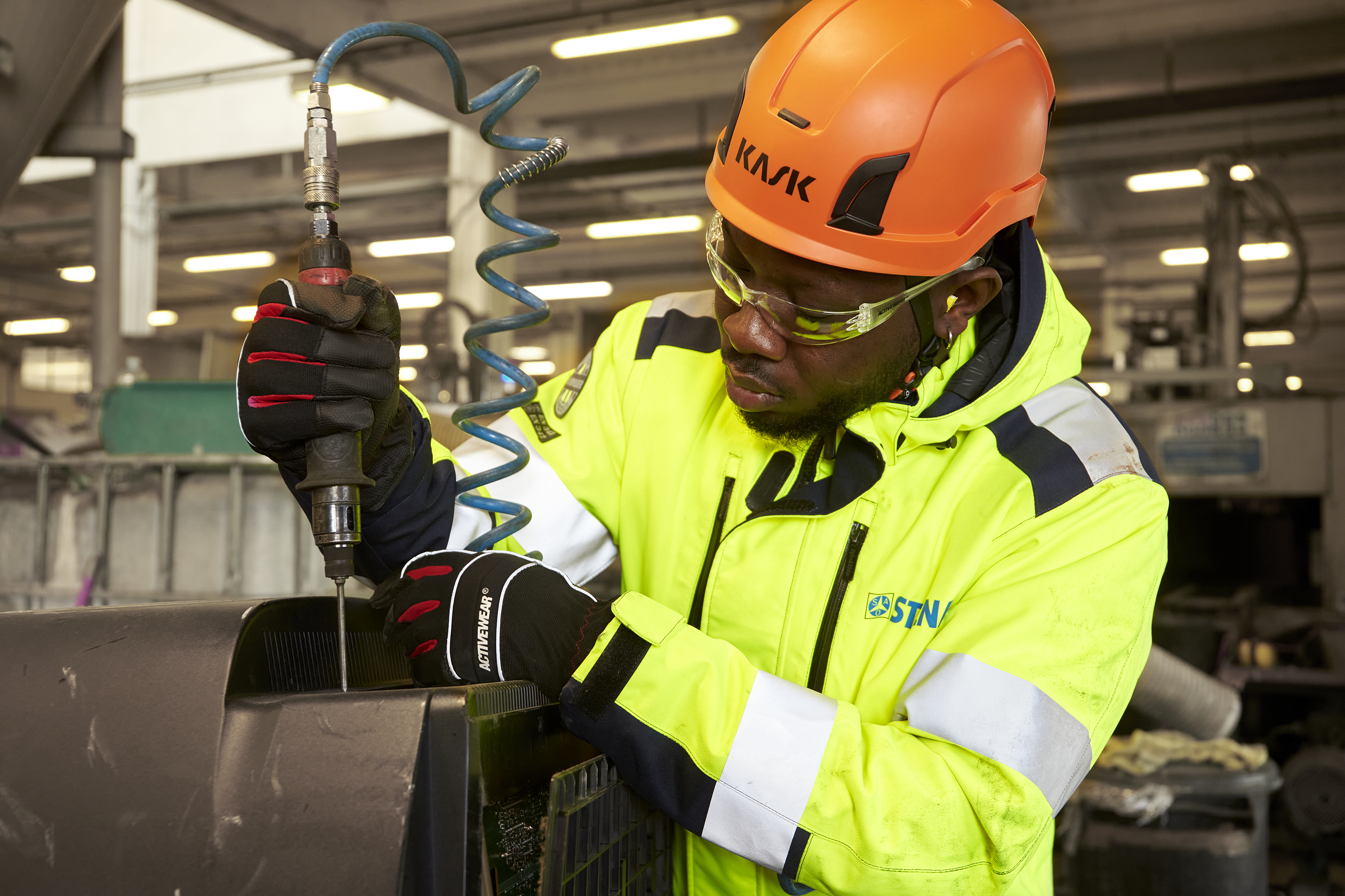 A Stena Metal Group employee at work in a Stena facility wearing hi-vis protective gear.