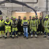 A group of Stena Metall Group employees in hi-vis gear and protective hard hats take part in the UN World Day for Safety and Health.