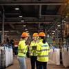 A group of three Stena Metall Group employees talk at Stena Nordic Recycling Center, Halmstad, Sweden. 