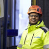 A male Stena Metall Group employee wearing hi-vis protective gear smiles and looks into the camera.