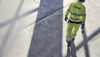 A rear shot of a Stena Metall Group employe wearing hi-vis gear and a protective hard hat.