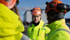 Christoffer Holmström, Group Compliance Officer för hälsa och säkerhet, klädd i High-vis-kläder, är på ett av sina platsbesök och pratar med de anställda.