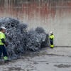 Två av Stena Metallkoncernens medarbetare står bredvid en stor hög med aluminium som är redo för återvinning.