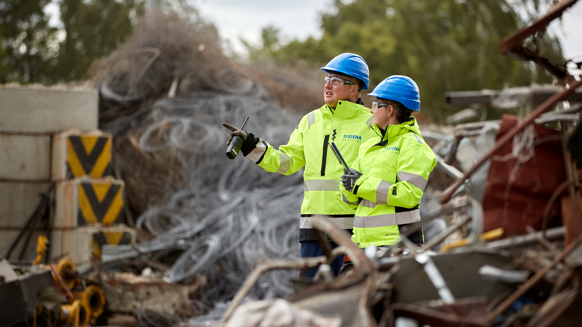Two people in helmets and yellow jackets