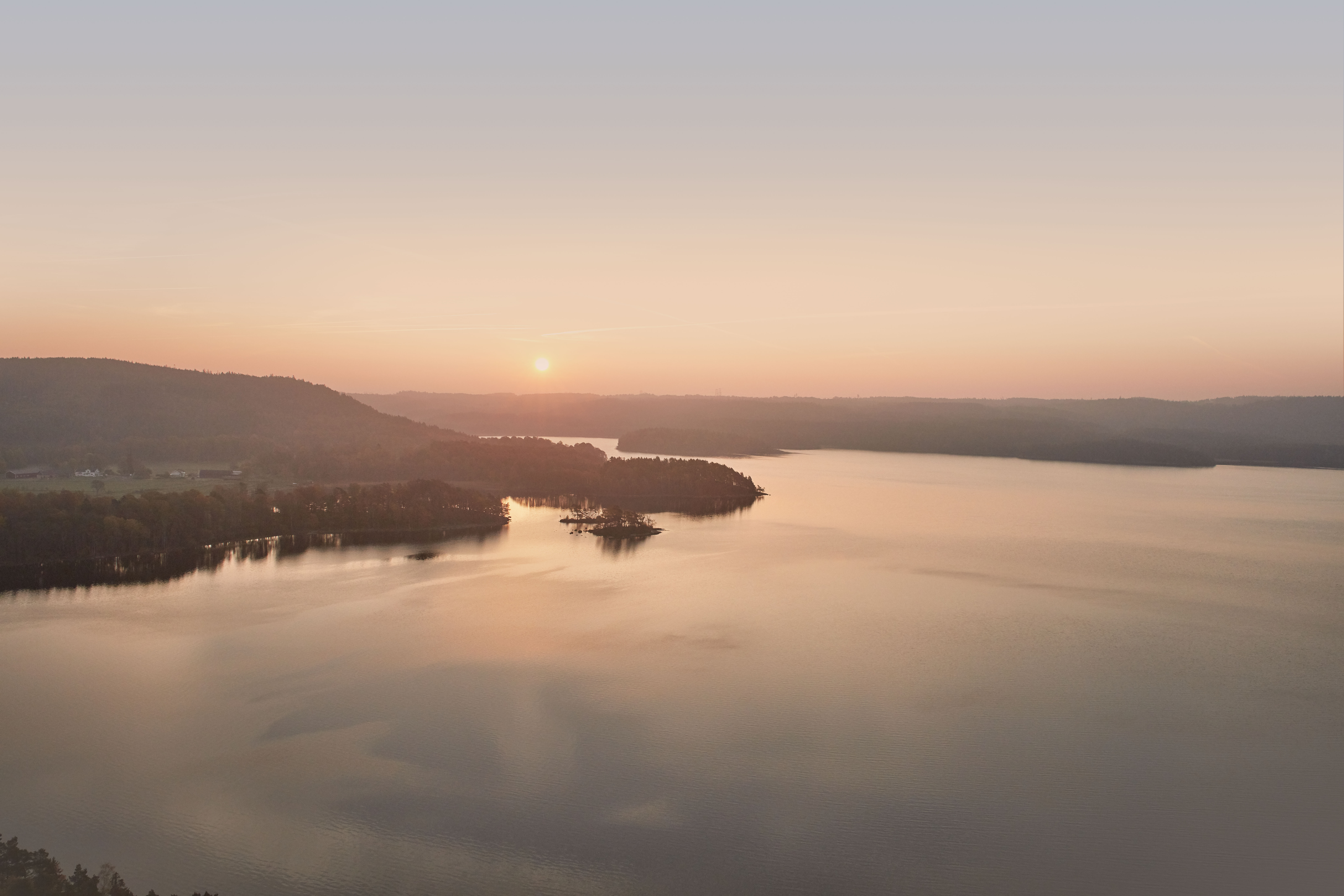Areal view of the sun setting over some body of water