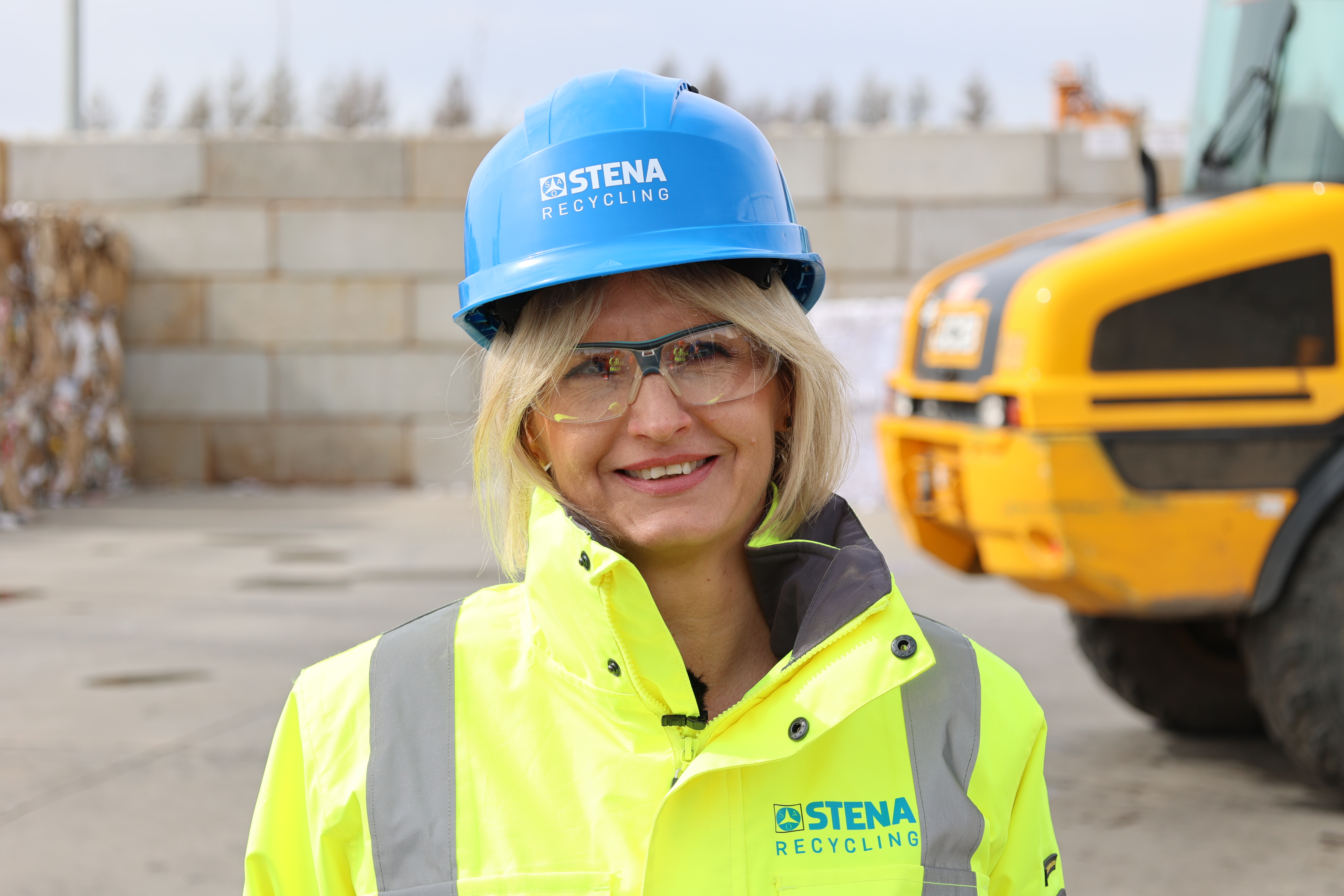 Iwona Korniluk, branch manager at a recycling facility, dressed in hi-vis protective gear, standing outside, talking about how they have managed to avoid accidents in 12 years.