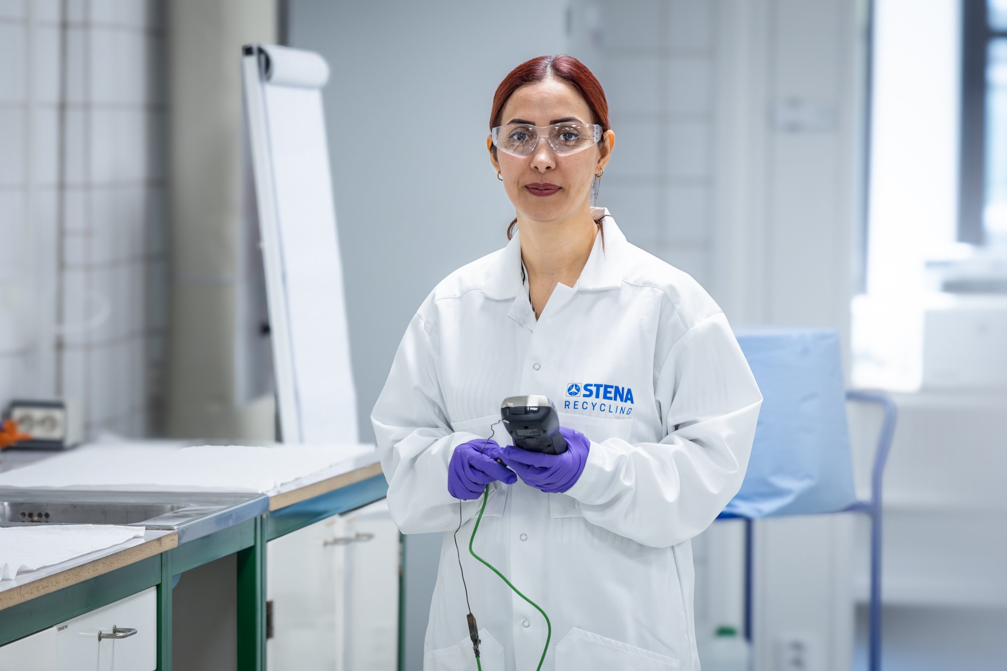 amira Akbari, a female Stena Recycling employee in lab coat in the recycling lab at Stena Nordic Recycling Center.