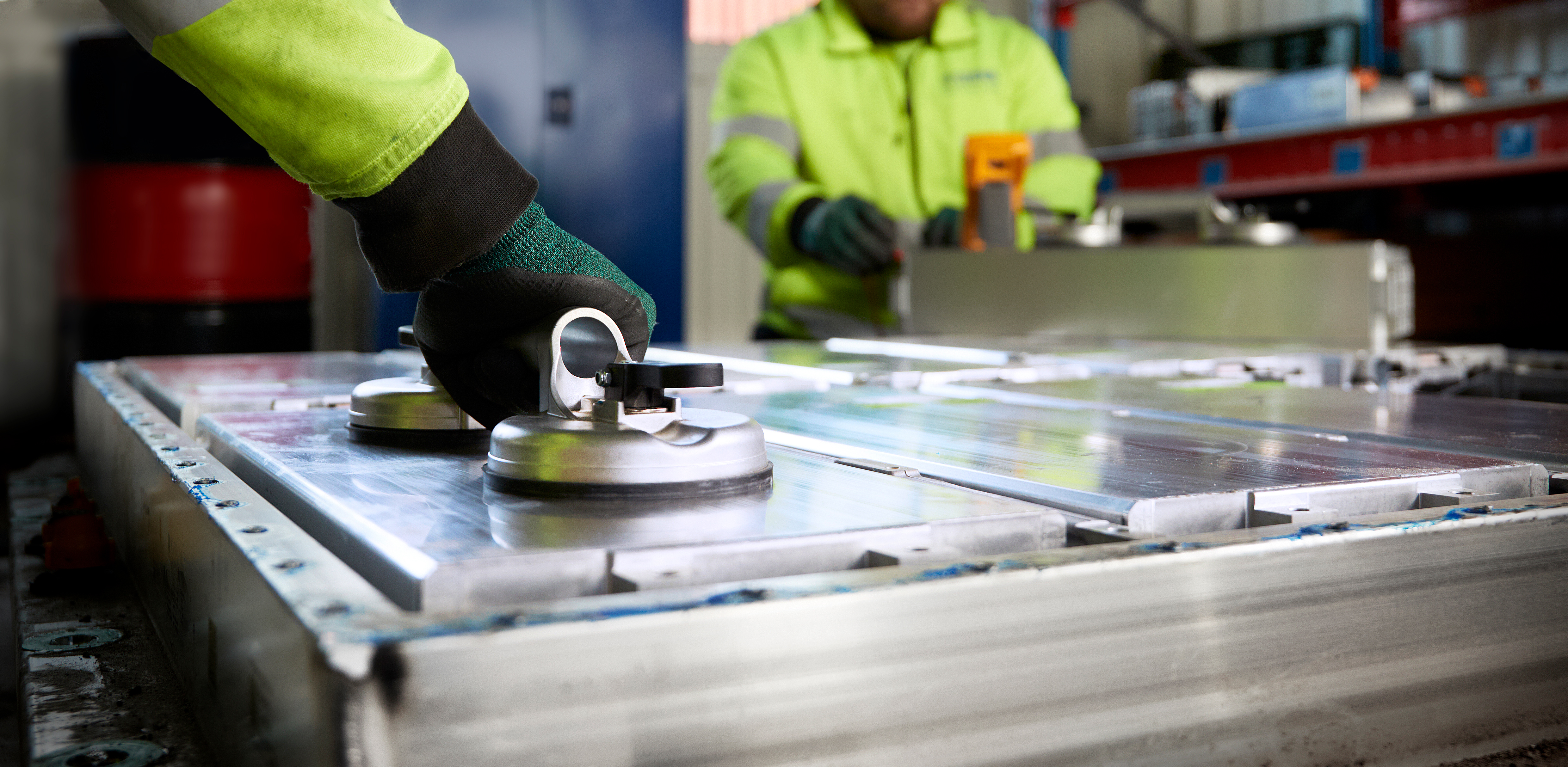 Stena Recycling employees picking up a battery at Stena Nordic Recycling Center, Halmstad, Sweden
