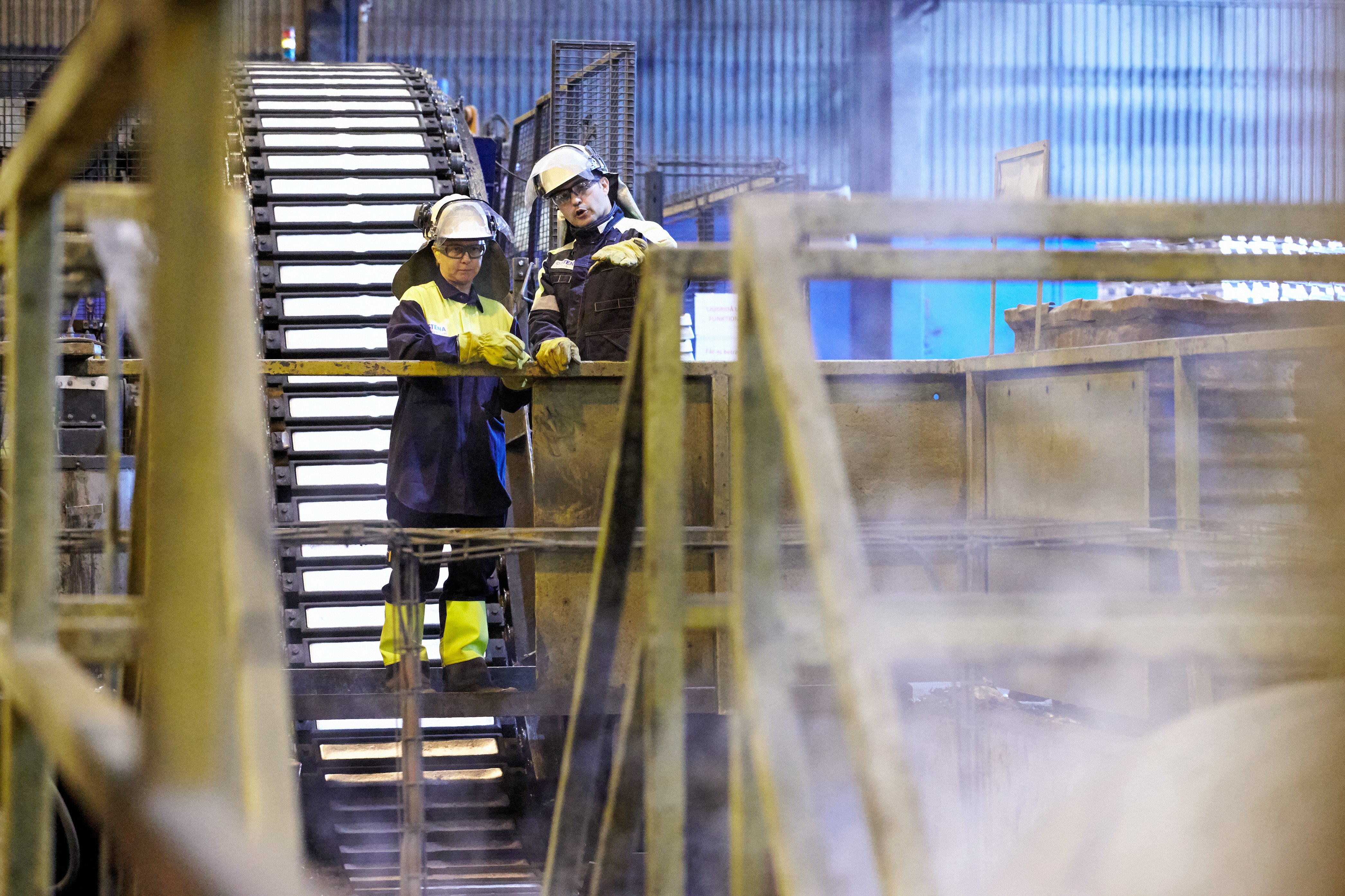 Två Stena Aluminium anställda som pratar med varandra