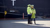 två personer står vid en återvinningsanläggning