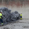 Två av Stena Metallkoncernens medarbetare står bredvid en stor hög med aluminium som är redo för återvinning.