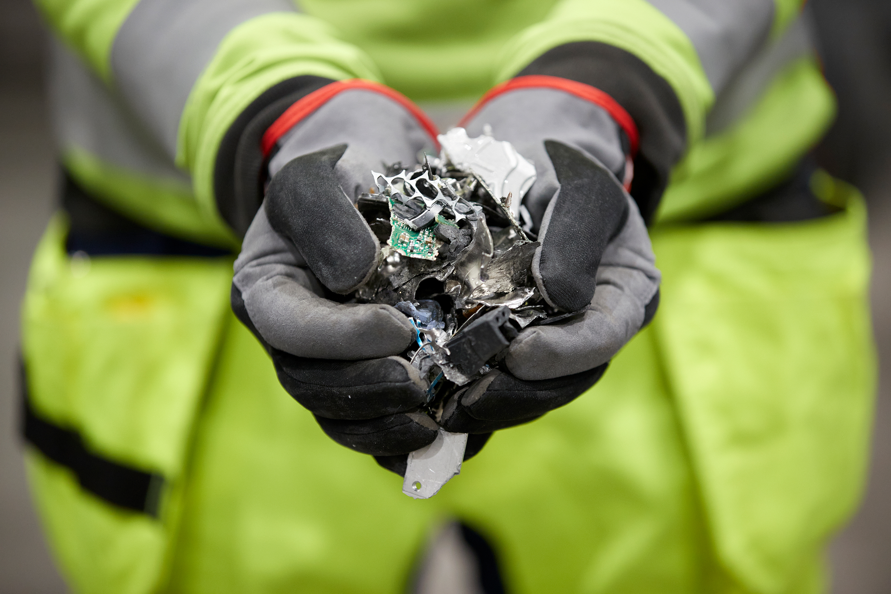 A Stena Confidential employee who's holding shredded electronics material