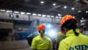 A group of Stena Metall Group employees in hi-vis protective gear walk together in a Stena facility.