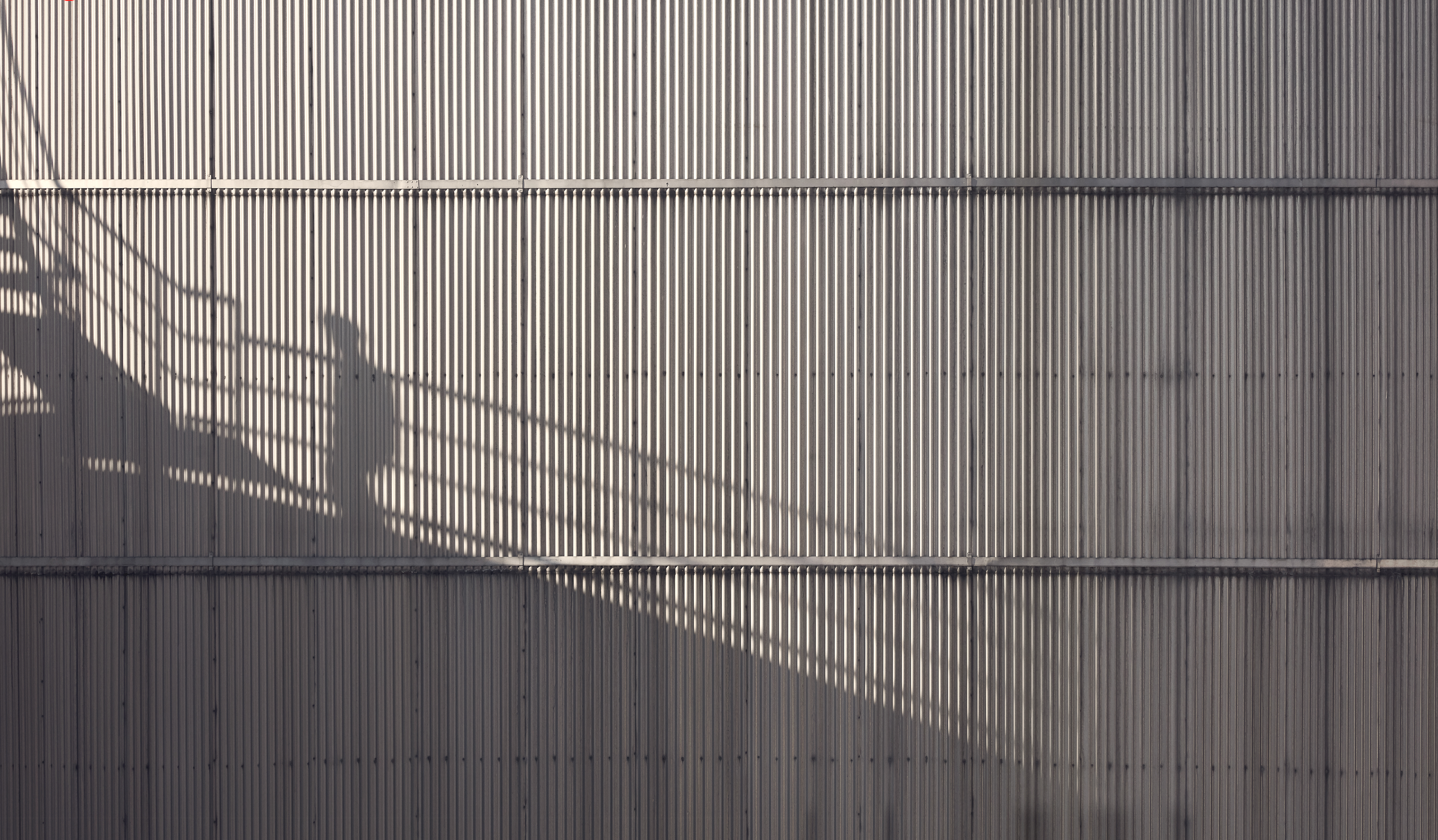 The shadow of a Stena Metall Group employee is shown high up on the side of a Stena facility.
